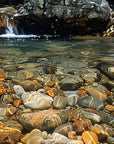 Papier peint cascades - lit de galets sous l'eau claire