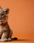 Papier Peint Animaux - Bébé Lion sur Fond Orange